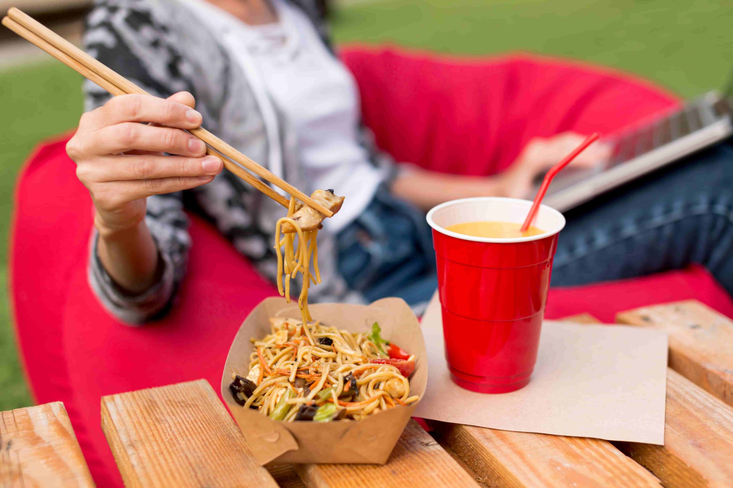 Chica comiendo comida asiática en un food truck